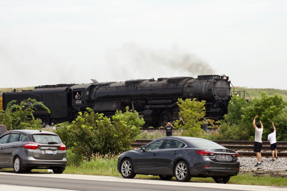 Big Boy 4014 passing a level crossing, the front headlight and smokebox door dominating the frame.